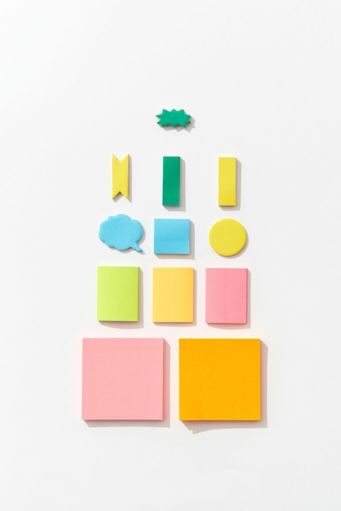 Vibrant sticky notes in various shapes and sizes arranged on a white background.